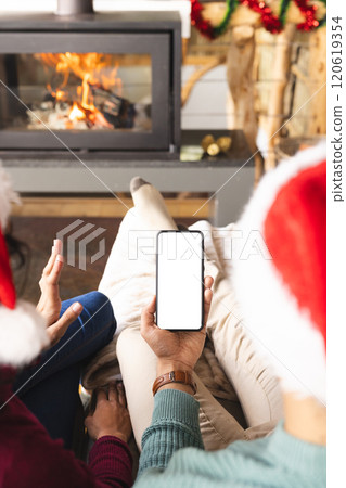 Biracial couple with santa hats having video call on smartphone at christmas at home, copy space Biracial couple with santa hats having video call on smartphone at christmas at home, copy space 120619354