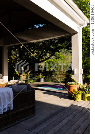 Outdoor furniture on terrace and yoga mat on deck in sunny garden, copy space Outdoor furniture on terrace and yoga mat on deck in sunny garden, copy space 120619403