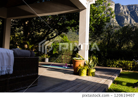 Outdoor furniture on terrace and yoga mat on deck in sunny garden, copy space 120619407