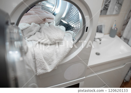 Close up view drying machine with washed and dried towels in and door open. Close up view drying machine with washed and dried towels in and door open. 120620133