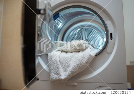 Close up view drying machine with washed and dried towels in and door open. Close up view drying machine with washed and dried towels in and door open. 120620134