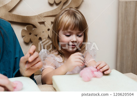 Little girl enjoys creative crafting activity with colorful materials indoors 120620504