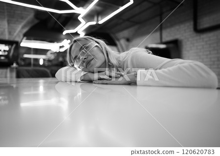 Woman resting at a modern cafe adorned with neon lights in the evening 120620783