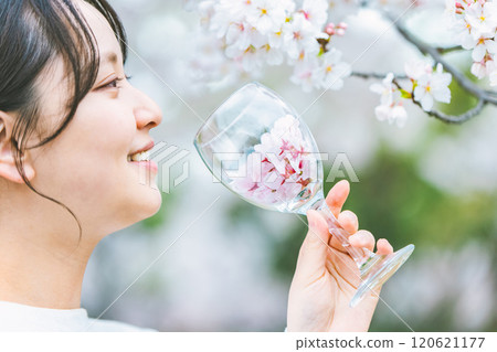 拿著裝滿櫻花花瓣的酒杯的女人 120621177