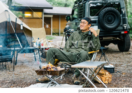 一名中年男性露營者在露營地的森林裡獨自露營 一名中年男性露營者在露營地的森林裡獨自露營 120621478