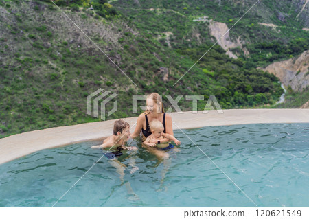 Mother with her toddler and teenage sons bathing in the hot springs of Grutas Tolantongo, Mexico. Family adventure, relaxation, and natural wellness concept 120621549