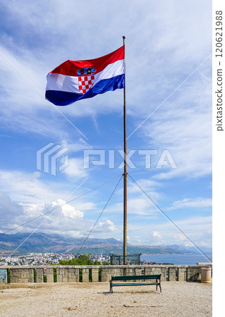 A large Croatian flag flies on a high mast on a mountain above the city of Split 120621988