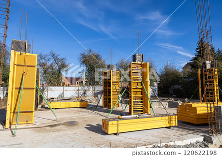 Yellow column formwork and steel rods at construction site, concrete pouring and foundation work Yellow column formwork and steel rods at construction site, concrete pouring and foundation work 120622198