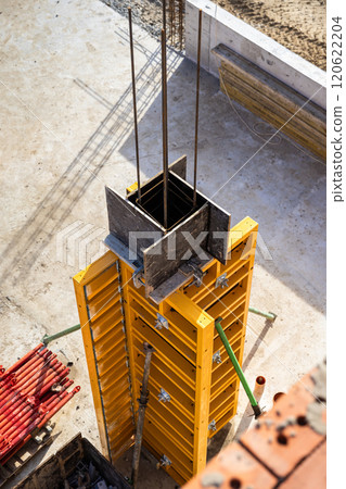 Vertical concrete formwork on construction site with reinforcement rods and framework in progress Vertical concrete formwork on construction site with reinforcement rods and framework in progress 120622204
