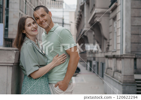 Happy couple of tourists walking embraced while sightseeing the town. Happy couple in front of palace of culture and science in Warsaw, Poland. Close up of a couple kissing. Happy couple of tourists walking embraced while sightseeing the town. Happy couple in front of palace of culture and science in Warsaw, Poland. Close up of a couple kissing. 120622294
