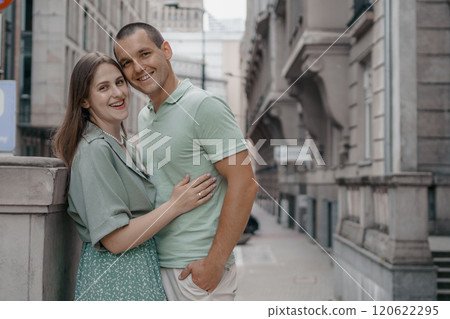 Happy couple of tourists walking embraced while sightseeing the town. Happy couple in front of palace of culture and science in Warsaw, Poland. Close up of a couple kissing. 120622295