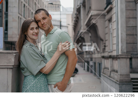 Happy couple of tourists walking embraced while sightseeing the town. Happy couple in front of palace of culture and science in Warsaw, Poland. Close up of a couple kissing. Happy couple of tourists walking embraced while sightseeing the town. Happy couple in front of palace of culture and science in Warsaw, Poland. Close up of a couple kissing. 120622296