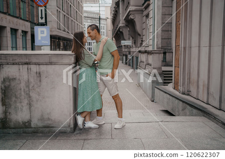 Happy couple of tourists walking embraced while sightseeing the town. Happy couple in front of palace of culture and science in Warsaw, Poland. Close up of a couple kissing. Happy couple of tourists walking embraced while sightseeing the town. Happy couple in front of palace of culture and science in Warsaw, Poland. Close up of a couple kissing. 120622307