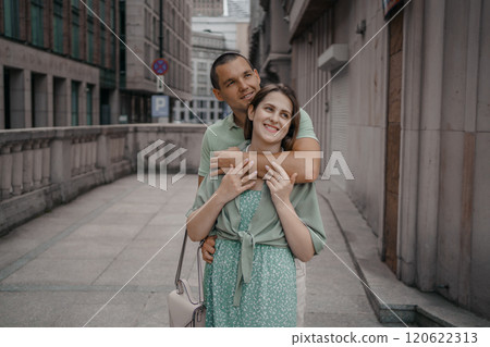 Happy couple of tourists walking embraced while sightseeing the town. Happy couple in front of palace of culture and science in Warsaw, Poland. Close up of a couple kissing. 120622313