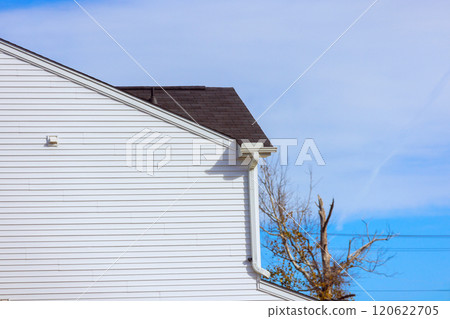 Bright white wooden house corner stands against sharp architectural lines nearby trees showcase hints Bright white wooden house corner stands against sharp architectural lines nearby trees showcase hints 120622705