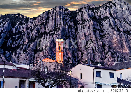 Views of the illuminated Church of Sant Corneli in Collbato, Barcelona at dusk, with the Montserrat mountain in the background Views of the illuminated Church of Sant Corneli in Collbato, Barcelona at dusk, with the Montserrat mountain in the background 120623343