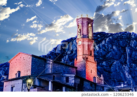 Views of the illuminated Church of Sant Corneli in Collbato, Barcelona at dusk, with the Montserrat mountain in the background 120623346