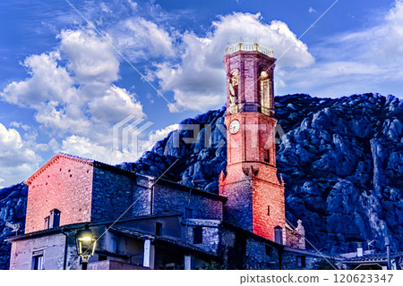 Views of the illuminated Church of Sant Corneli in Collbato, Barcelona at dusk, with the Montserrat mountain in the background Views of the illuminated Church of Sant Corneli in Collbato, Barcelona at dusk, with the Montserrat mountain in the background 120623347