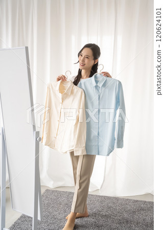 Young woman choosing clothes indoors 120624101