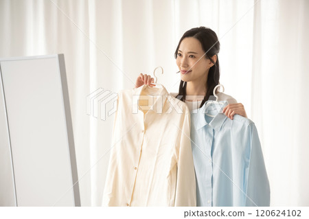 Young woman choosing clothes indoors Young woman choosing clothes indoors 120624102