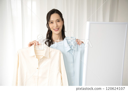 Young woman choosing clothes indoors Young woman choosing clothes indoors 120624107