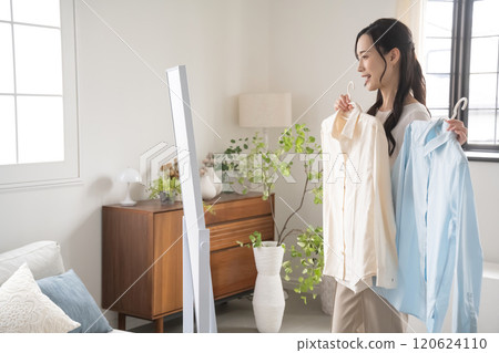 年輕女子在室內選擇衣服 年輕女子在室內選擇衣服 120624110