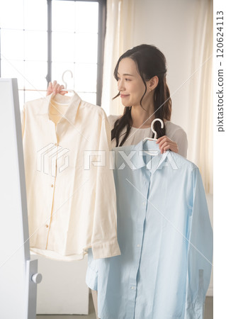 Young woman choosing clothes indoors 120624113