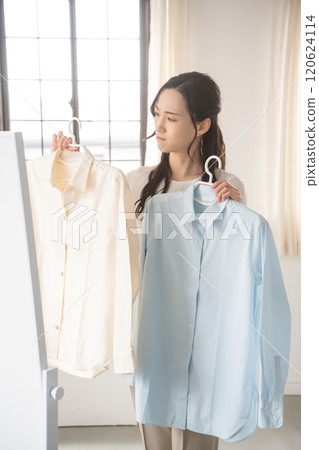 Young woman choosing clothes indoors 120624114