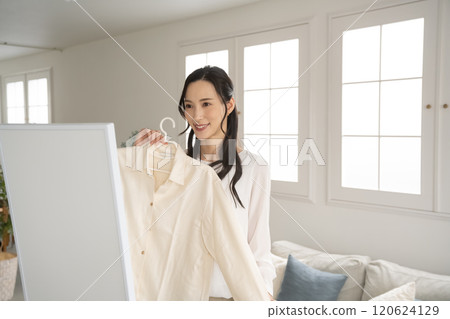 Young woman choosing clothes indoors 120624129