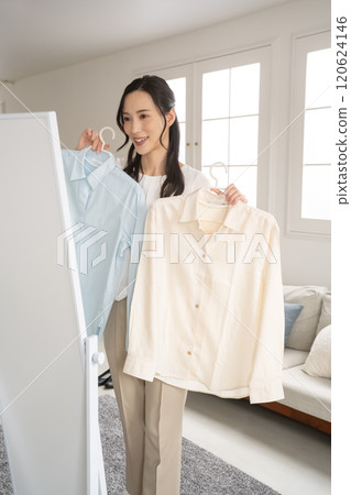 Young woman choosing clothes indoors 120624146