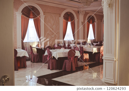 an empty hall is a classic restaurant with curtains white tablecloths and Romanesque decor. High quality photo 120624293