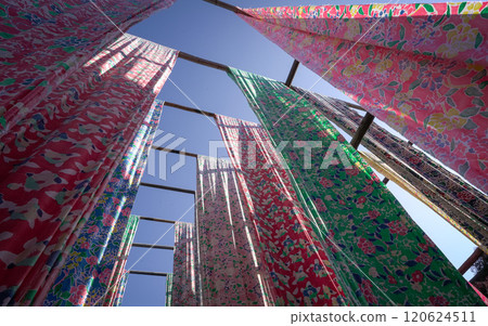Rows of colorful dye cloth hanging outside in the sun. Rows of colorful dye cloth hanging outside in the sun. 120624511