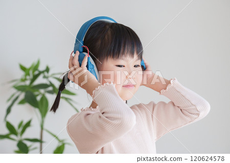 Hearing-impaired child wearing earmuffs 120624578