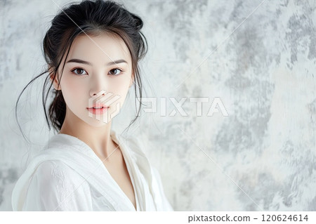 Asian girl white dress stand against white wall of fluttering fabric and silk 120624614