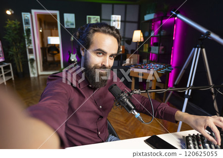 ASMR artist using quality mic and selfie camera in studio to do anti stress video, whispering tingling sounds. POV of man using professional microphone to get sleep inducing audio for zen meditation 120625055
