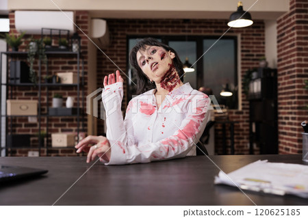 Portrait of burnout woman with tired expression limping on office desk chair, looking like zombie after grinding too much. Businesswoman covered in scars exhausted after being overworked 120625185