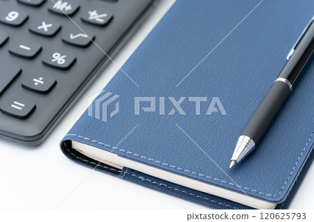Close-up of a notebook, ballpoint pen and calculator 120625793