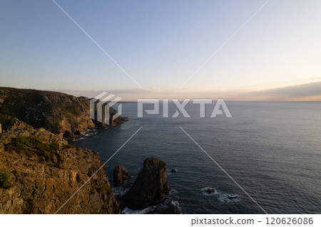 Coastal landscape at dusk with rocky cliffs and calm ocean waters Coastal landscape at dusk with rocky cliffs and calm ocean waters 120626086
