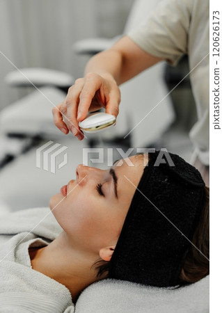 Woman receiving a facial treatment in a serene spa setting during the afternoon Woman receiving a facial treatment in a serene spa setting during the afternoon 120626173