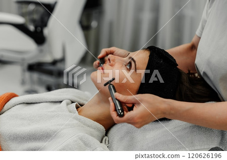 Client receiving facial treatment at a skincare studio on a relaxing day 120626196