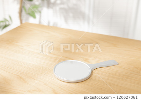 A hand mirror on a table 120627061