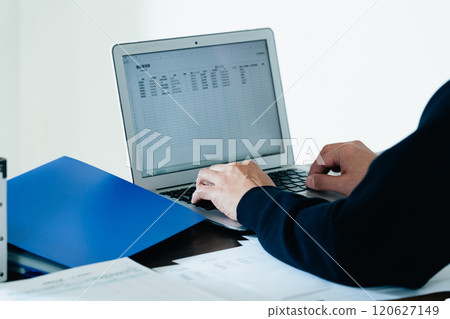 Rear view of a man operating a computer at a desk 120627149