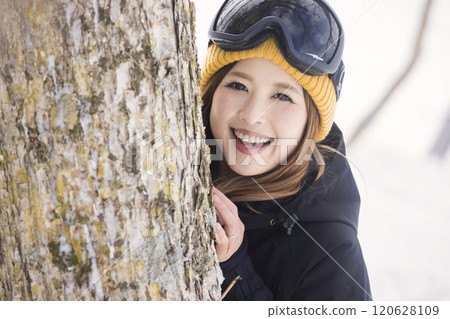 Snowboard girls appearing from the trunk of a tree on the slopes Snowboard girls appearing from the trunk of a tree on the slopes 120628109