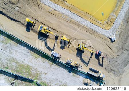 Heavy construction machinery works diligently on new development area moving dirt, gravel for foundation preparation. Heavy construction machinery works diligently on new development area moving dirt, gravel for foundation preparation. 120628446