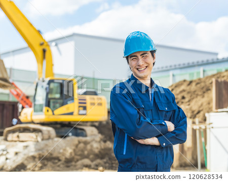 一名男工人微笑地站在工地前 一名男工人微笑地站在工地前 120628534