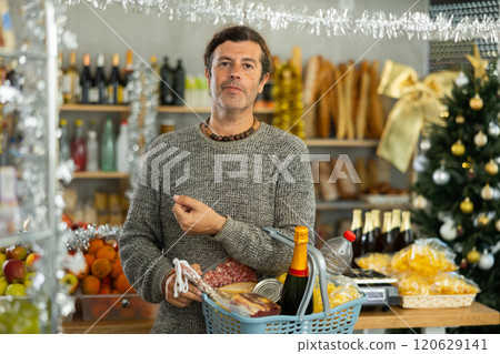 Man with basket shopping in holiday-decorated grocery store Man with basket shopping in holiday-decorated grocery store 120629141