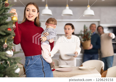 Woman decorating Christmas tree 120629158