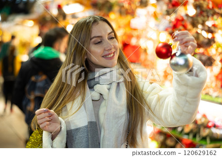 Portrait of dreamily happy girl with Christmas balls in her hands at a street fair in evening Portrait of dreamily happy girl with Christmas balls in her hands at a street fair in evening 120629162