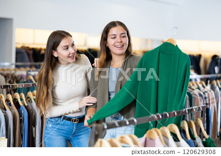 Portrait of two positive women choosing cardigan in clothing shop Portrait of two positive women choosing cardigan in clothing shop 120629308