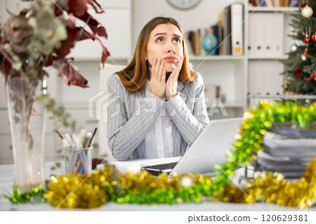 Sad woman bookkeeper working during Christmastime Sad woman bookkeeper working during Christmastime 120629381